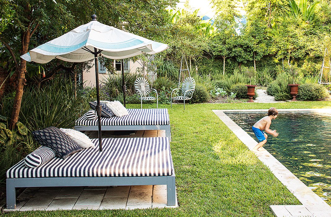 Young Ruffin prepares for a plunge into the backyard’s saltwater pool. The pool beds and umbrella were custom-made, and the metal chairs are vintage.
