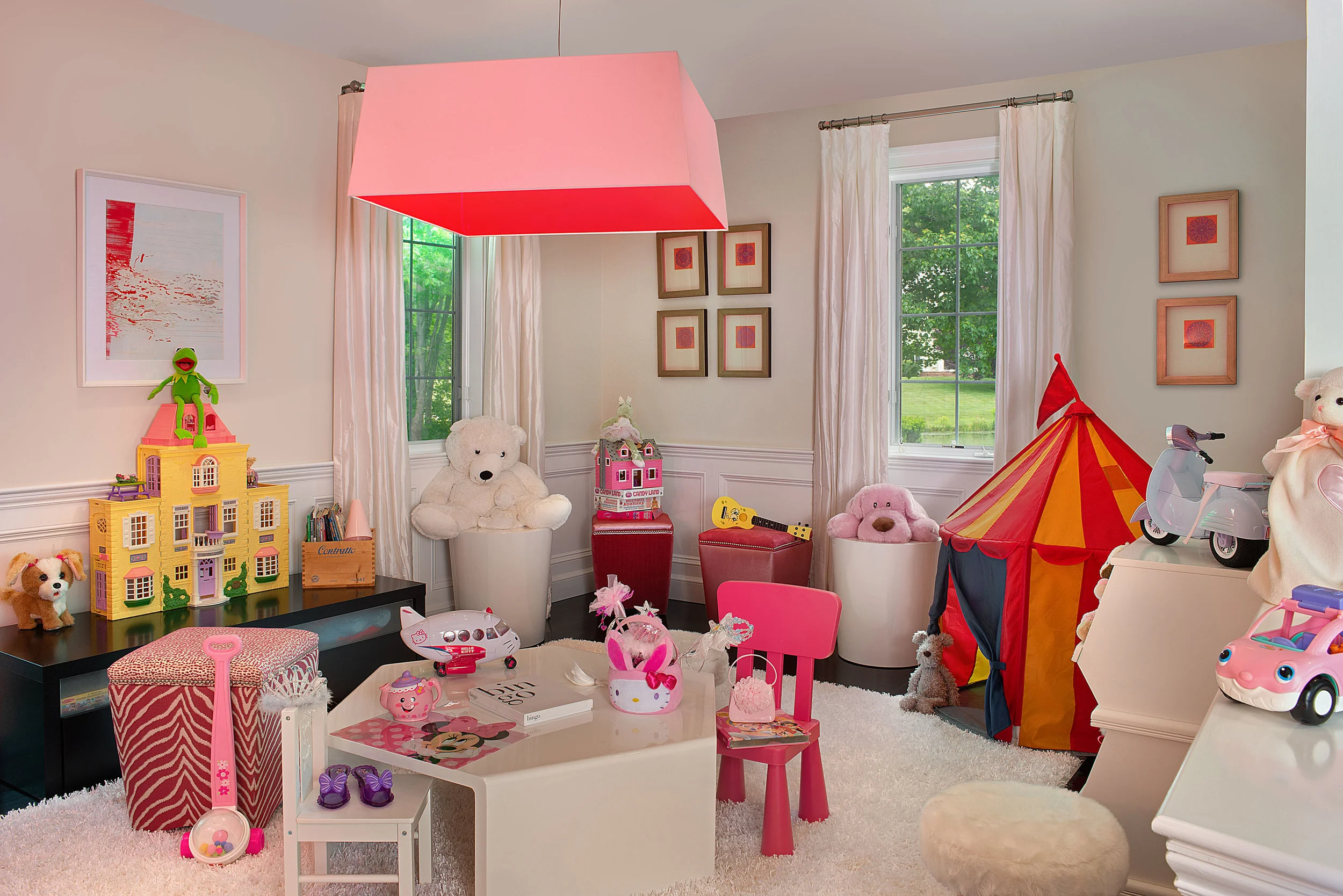 We turned the billiard room into a modern play room for the couple’s young daughter. We kept the core design elements, dark floors and white silk panels, to maintain the cohesive flow through the first floor. The bright colored toys contrasted by white walls create a “fun” space for playtime. 