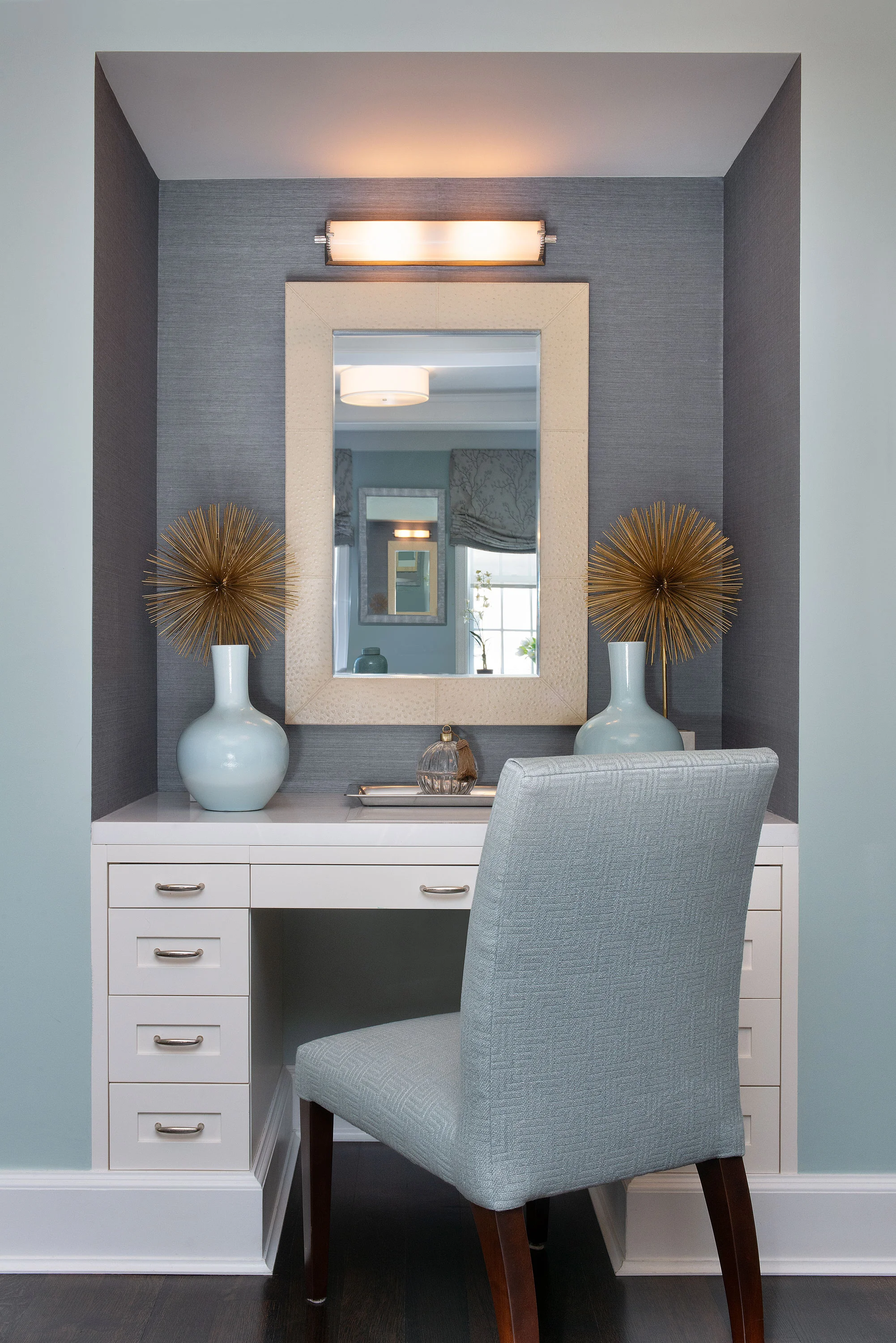 The vanity chair was done in soft aqua fabric to tie into the wallpaper and the other furnishings in the bedroom.