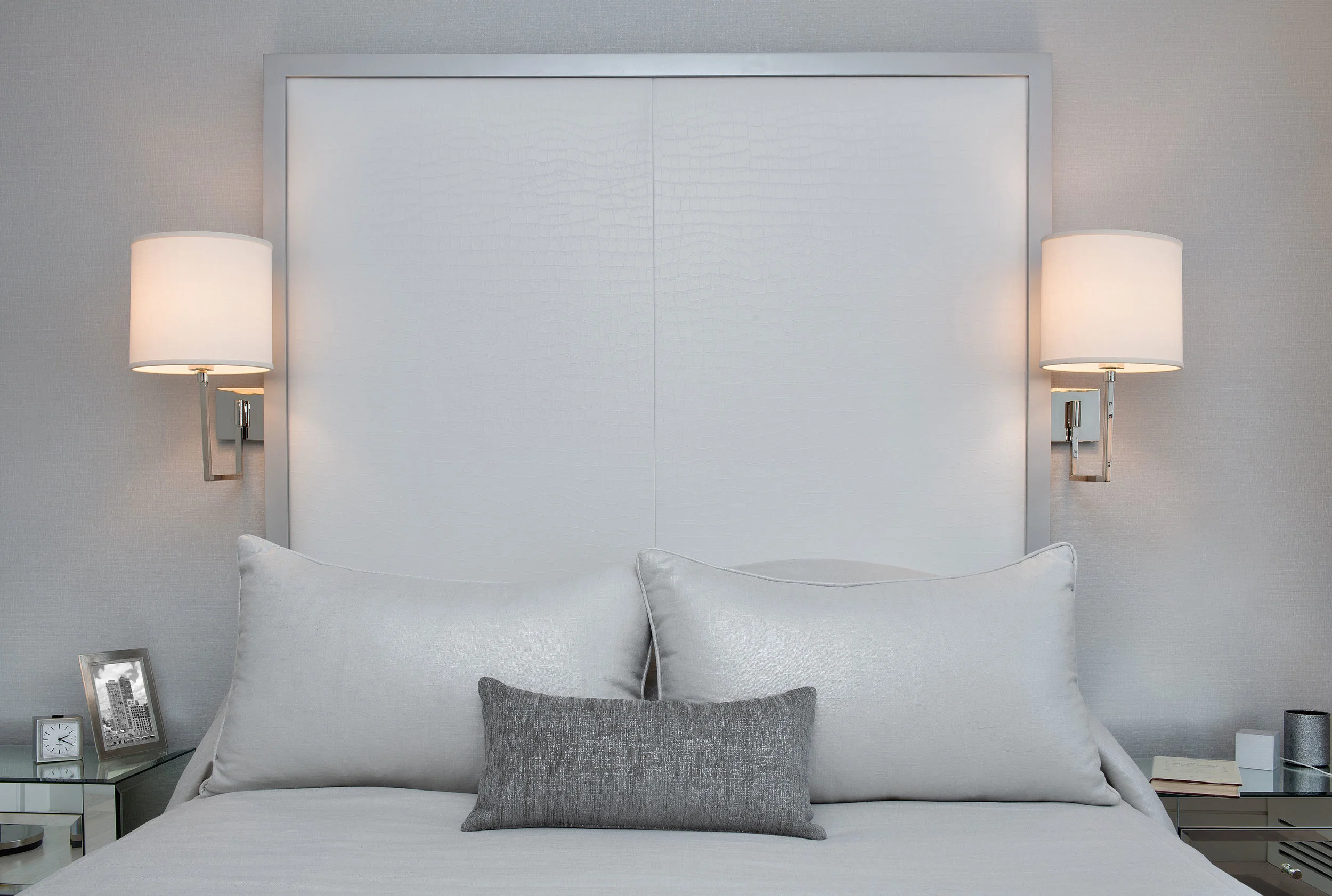 The leather textured headboard creates a feeling of height in a space that has lower ceilings. 