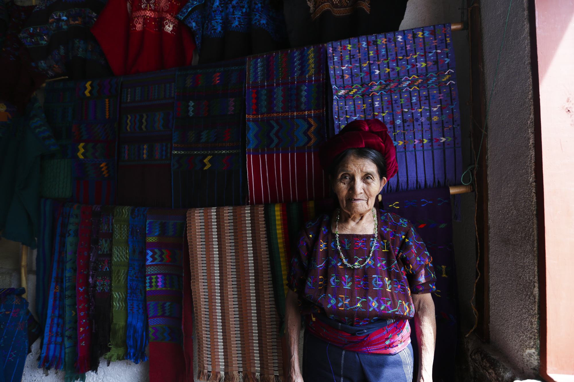 Catorina posses in front of her textiles in San Antonio Palopó, Guatemala, on August 4, 2018. Catorina said that one table cloth can take up to four months to make.