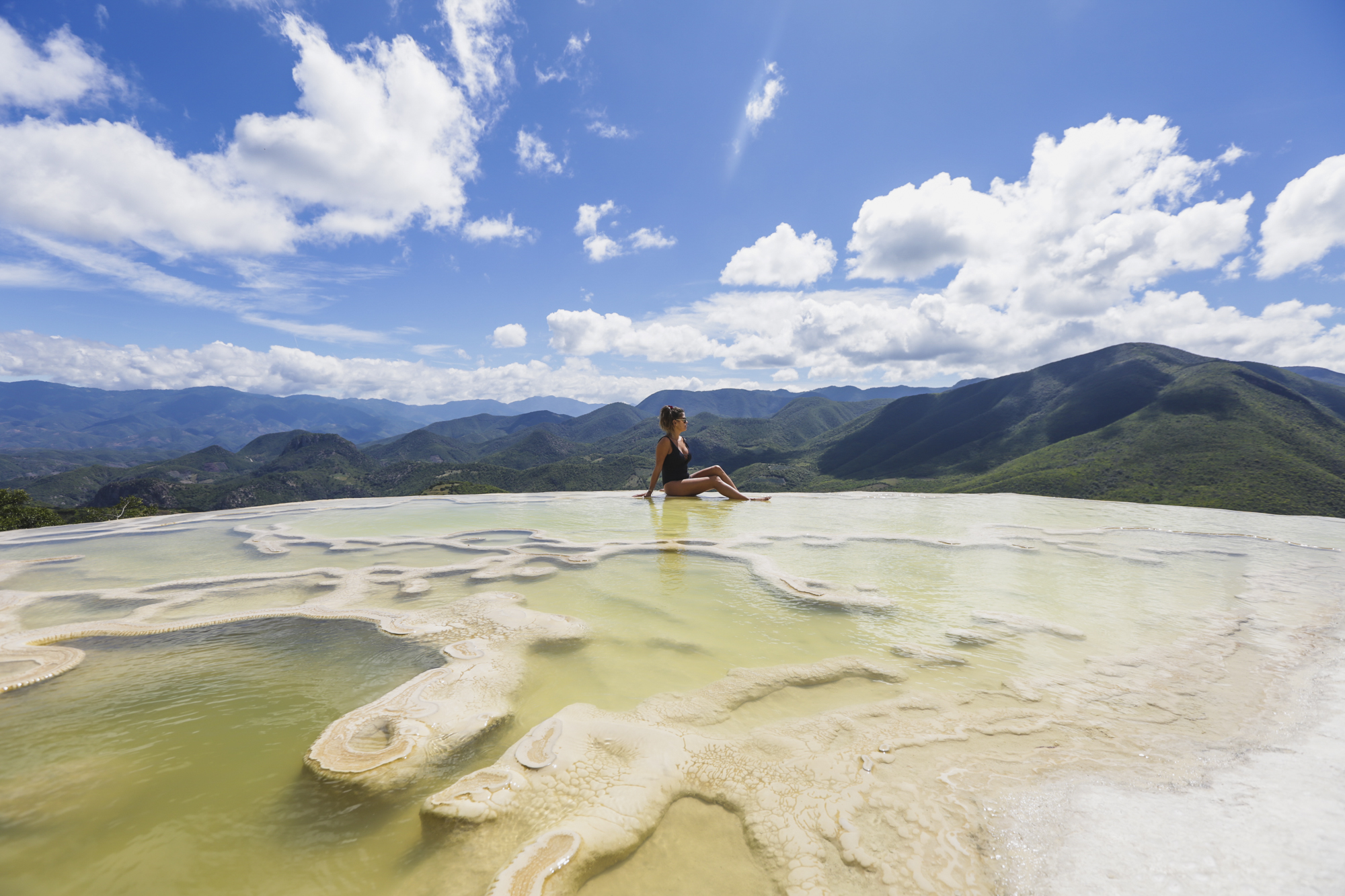 Victoria sits on the edge of Hierve el Agua, just outside of Oaxaca, Mexico, on October 30, 2018. Hierve el Agua is a set of natural rock formations in the that resemble cascades of water. These formations are created by fresh water springs, whose water is over-saturated with calcium carbonate and other minerals. 