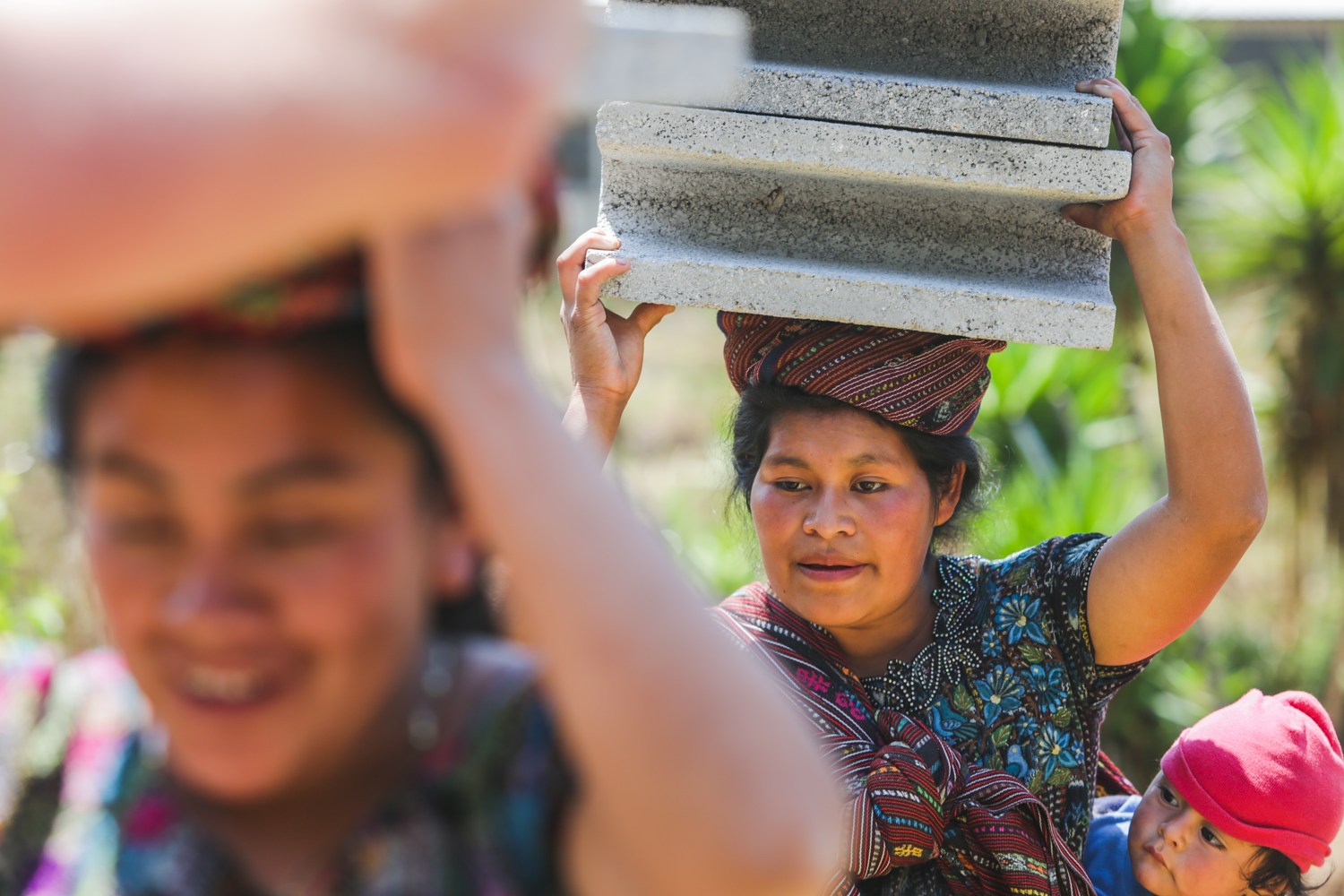 Mothers from Peña Blanca help carry concrete blocks to the Peña Blanca Preschool for volunteers to help build a wall around the school to protect the area. Peña Blanca is a small town in rural Guatemala primarily inhibited by indigenous families.