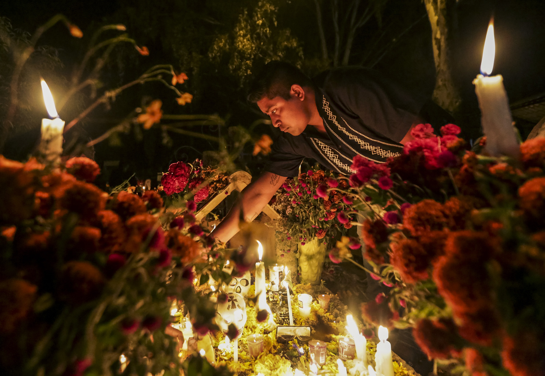 A man lights candles on a family members’ grave during Dîa de Muertos (Day of the Dead) in Oaxaca, Mexico, on October 31, 2018. Dîa de Muertos is a Mexican holiday where family and friends gather to celebrate and remember people who have died, and help support their spiritual journey.