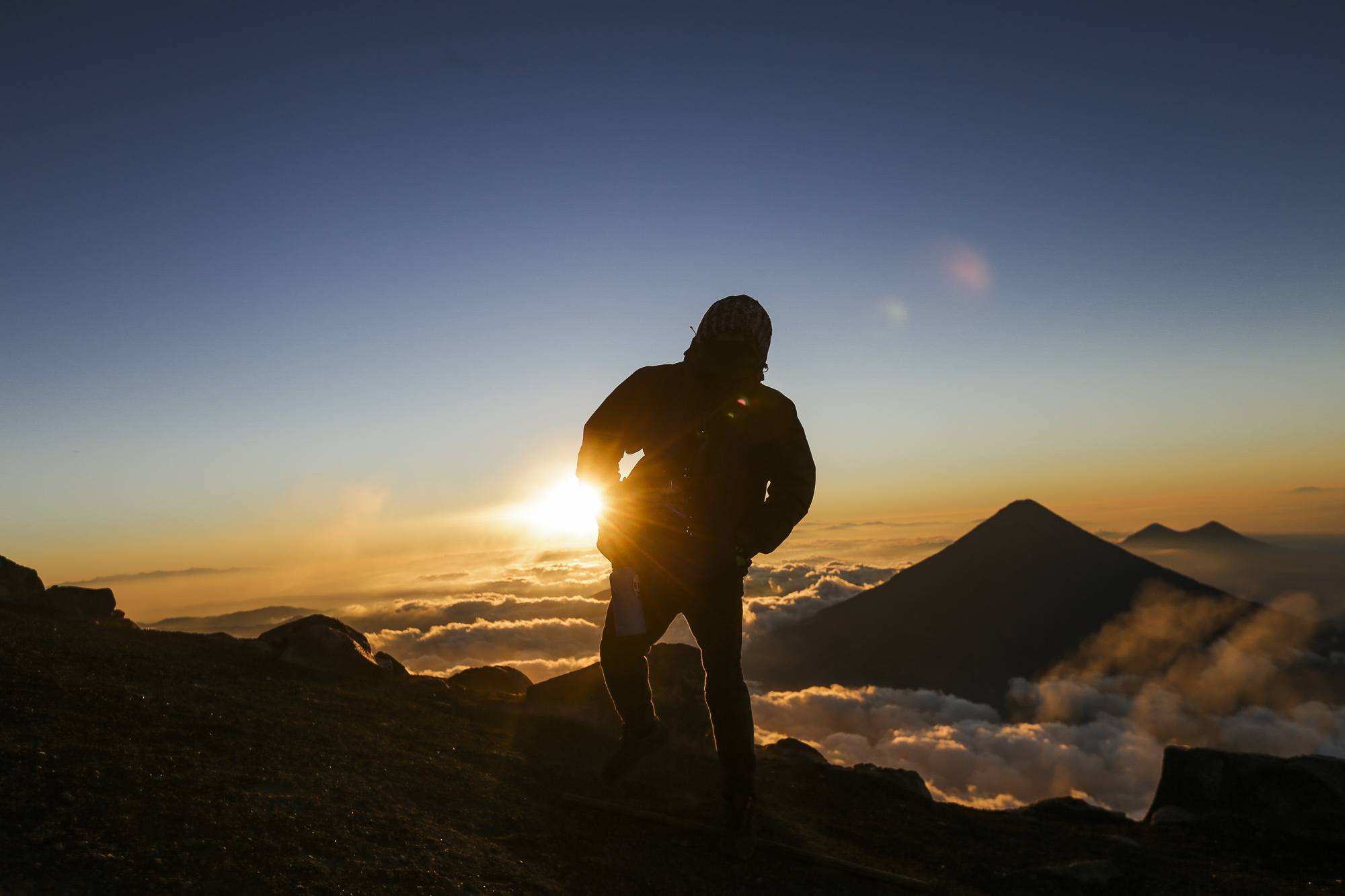 Jason Gegere reaches the top of Volcán Acatenango at 5:00 am just as the sun begins the rise. Acatenago lies next to Volcán Fuego, which an active volcano that erupts constantly throughout the day and night.