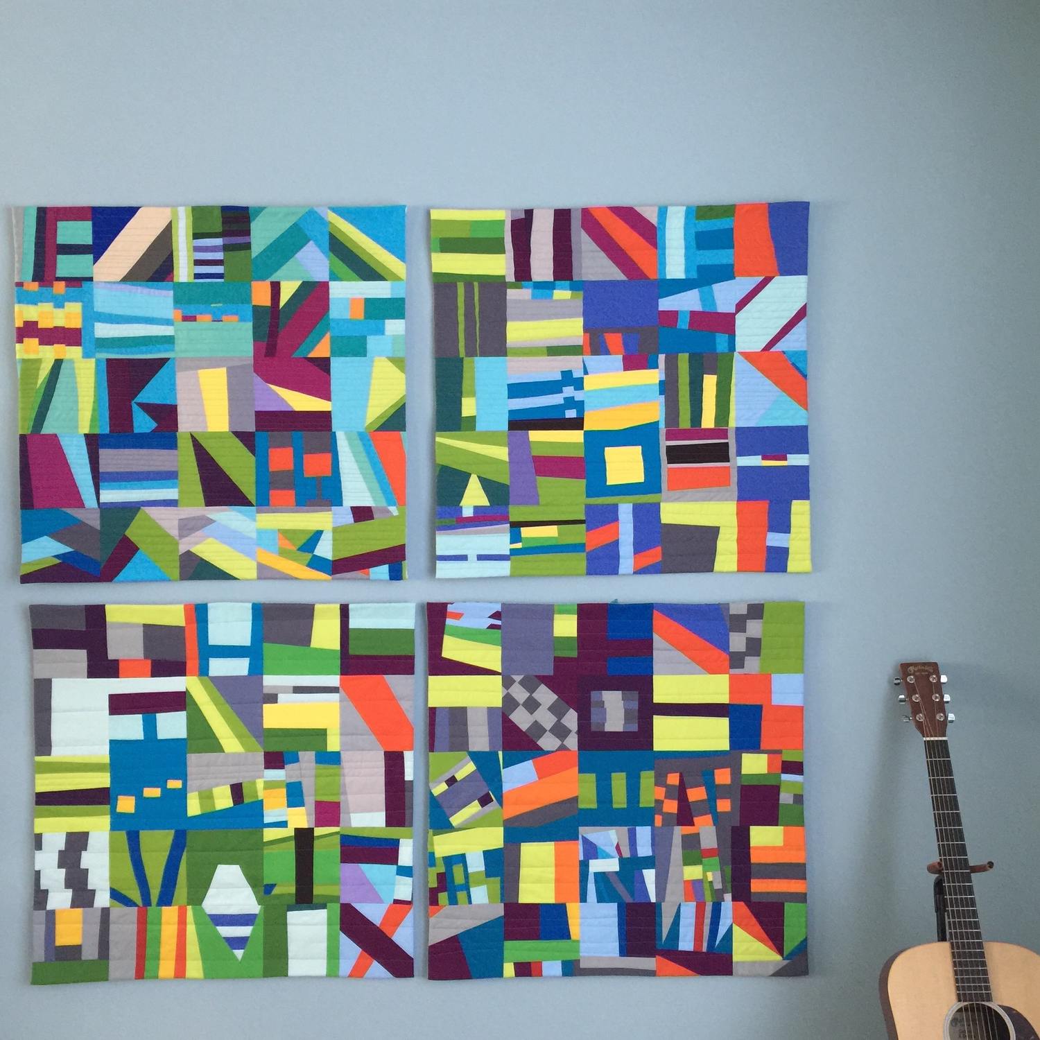 All 4 quilts in my 100 Day series, 2015. The guitar is there for scale.