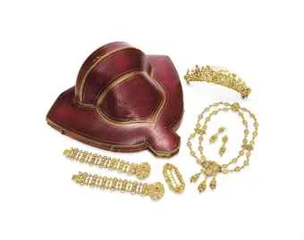 AN ANTIQUE GOLD PARURE Comprising a sculpted gold necklace of foliate motif; two bracelets, a brooch, a pair of ear pendants and a tiara en suite, circa 1830, necklace 17½ ins., bracelets 7 ins., with French assay marks, French importation marks and maker’s marks, in a red leather fitted case (6) Christie’s Sale 2694