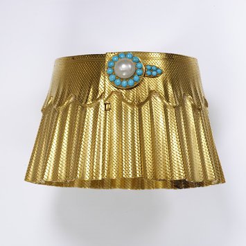 England, c 1860 Gold with turquoise and pearls ‘Manchette’ or cuff bracelets became fashionable in France in the 1850s and 60s and then spread to England. In a letter to her daughter, the Princess Frederick William of Prussia, in 1861 Queen Victoria described a wedding anniversary gift of ‘a beautiful bracelet which he got at Coburg- from Gotha- a large elastic gold bracelet like a cuff – and so pretty’. The gold on this bracelet is textured to look like cloth. A buttonhole and button are formed of the turquoise and pearl fashionable in the period. V&A Museum