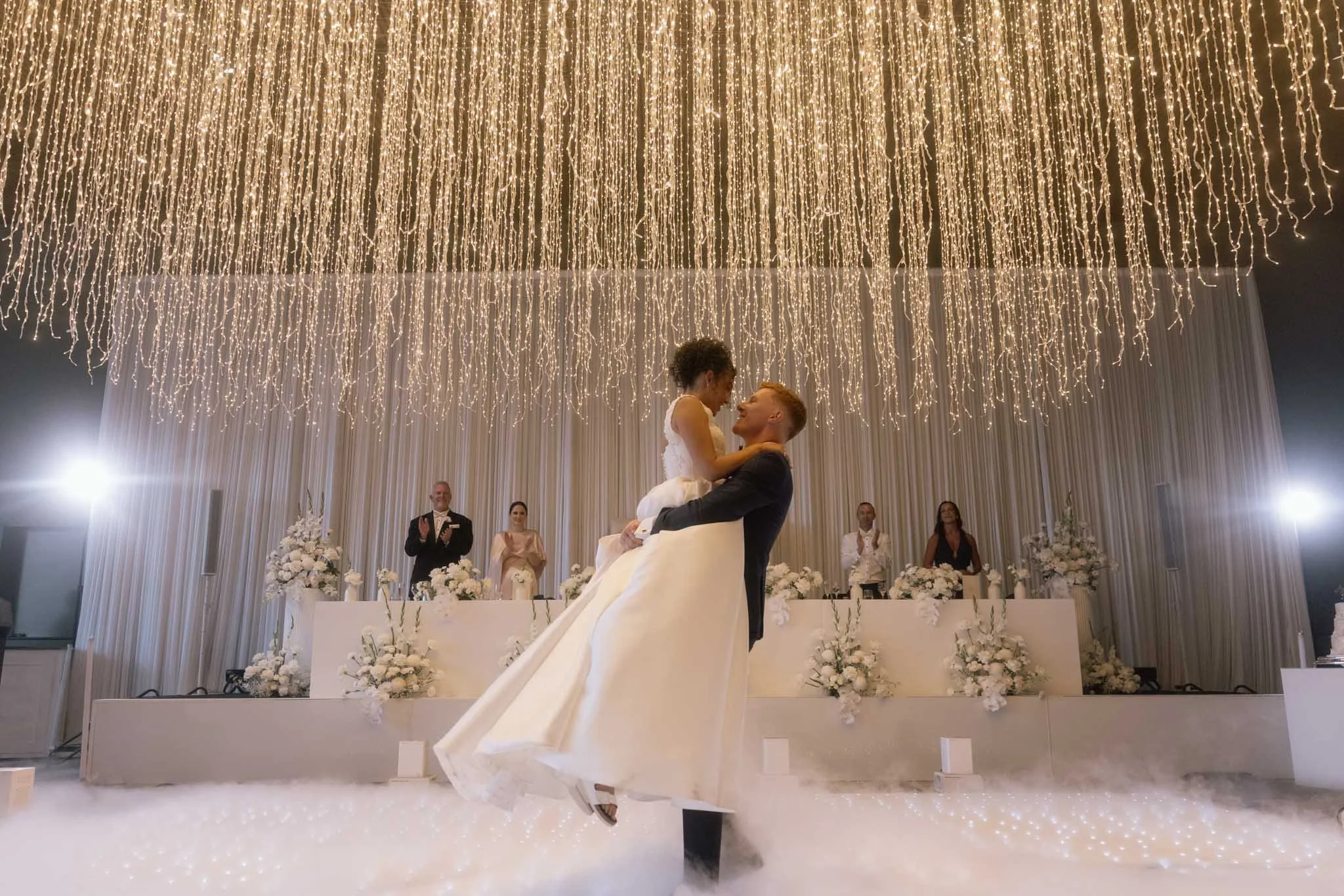groom-lifts-bride-wedding-photographer-videographer.jpg