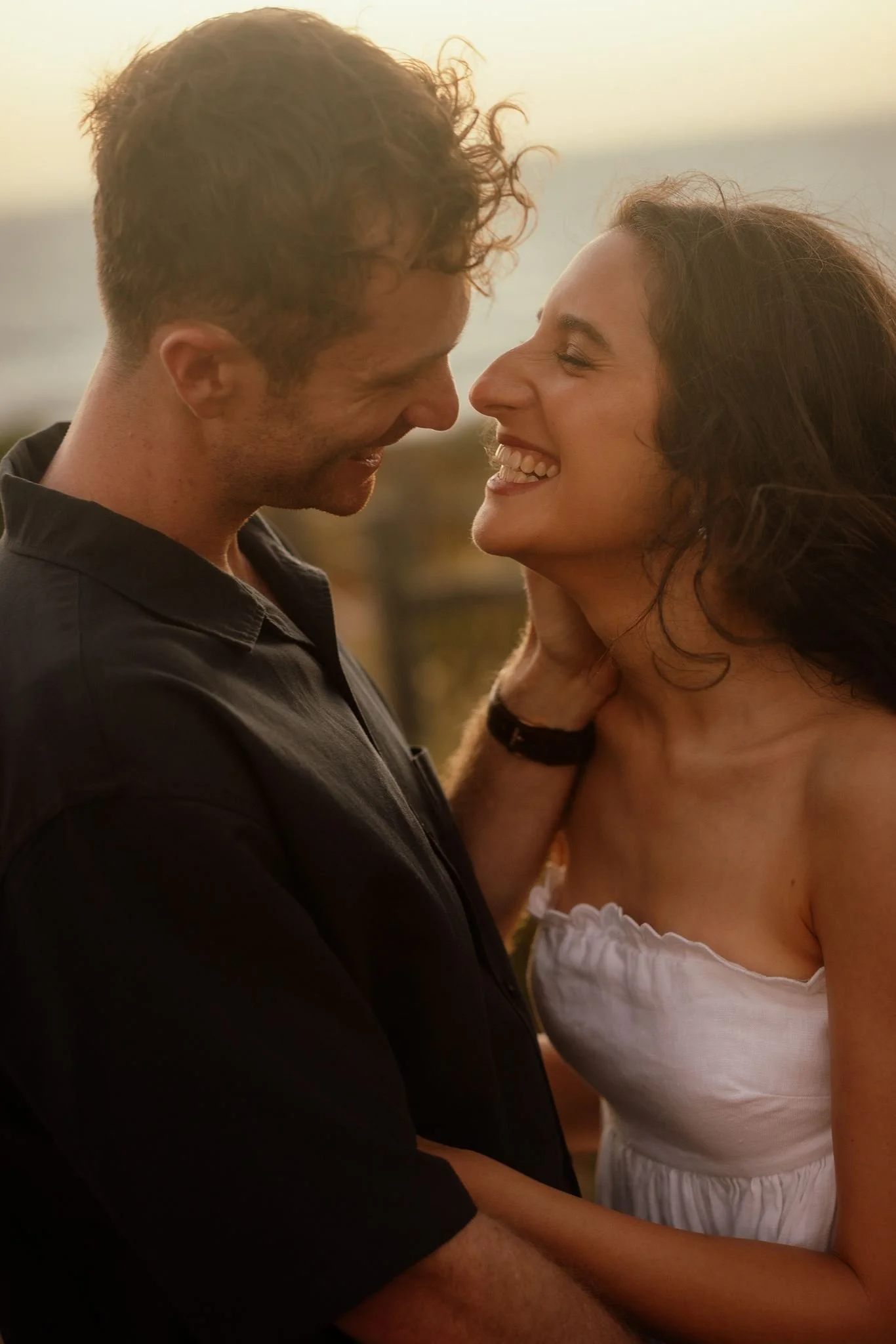A couple share a joyful laugh nose-to-nose during a golden-hour pre-wedding shoot at Perry's Paddock, Perth.