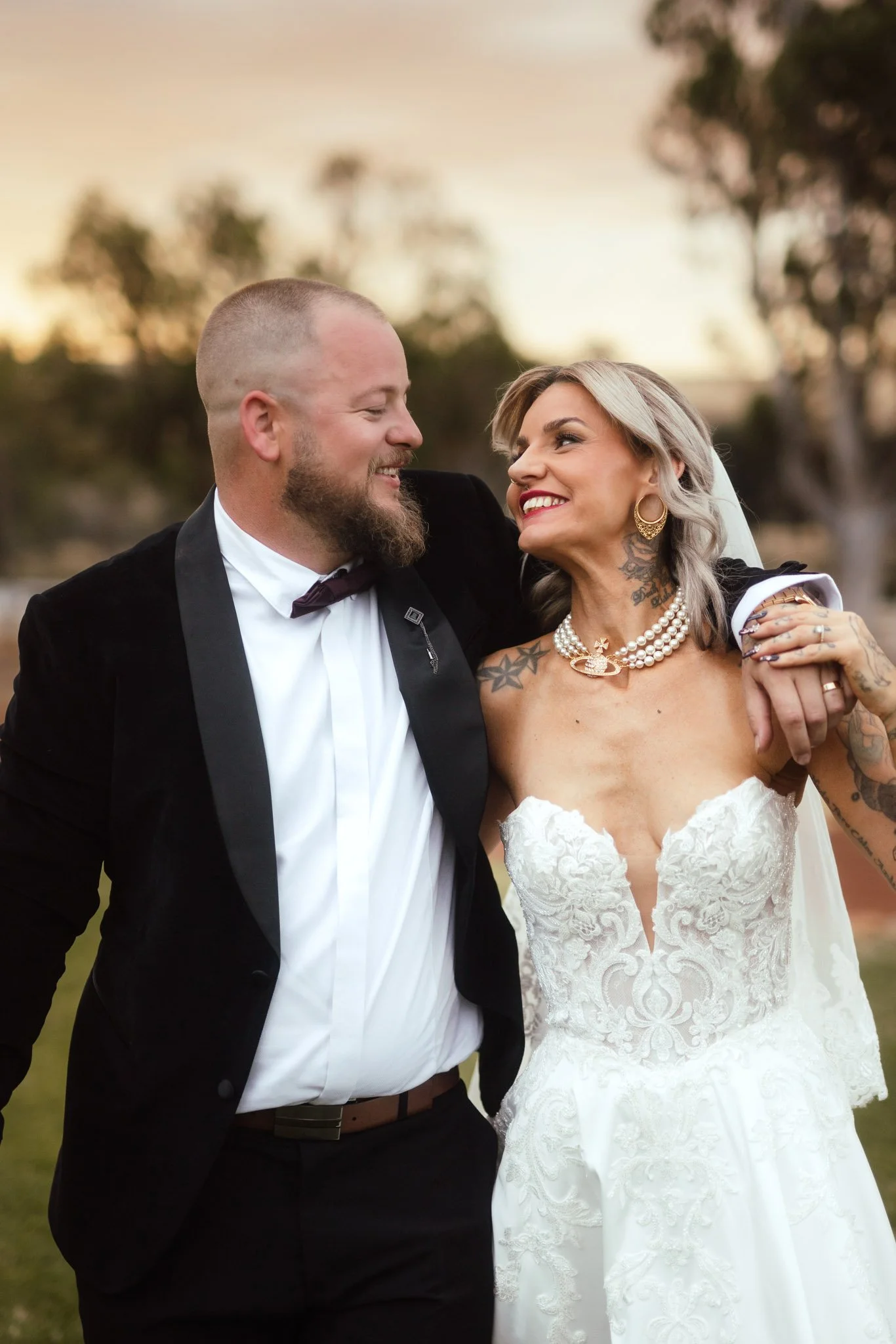 A close-up, candid couple's portrait of a bride and groom sharing a laugh while walking during sunset portraits at Buckland Estate, a premier hidden outback wedding venue near Perth