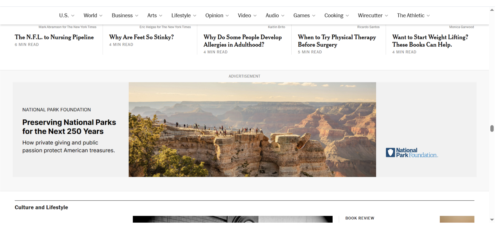 A digital homepage of a news website featuring articles on various topics, with a prominent advertisement for preserving national parks showing a panoramic view of the Grand Canyon at sunset, including tourists walking along the edge.