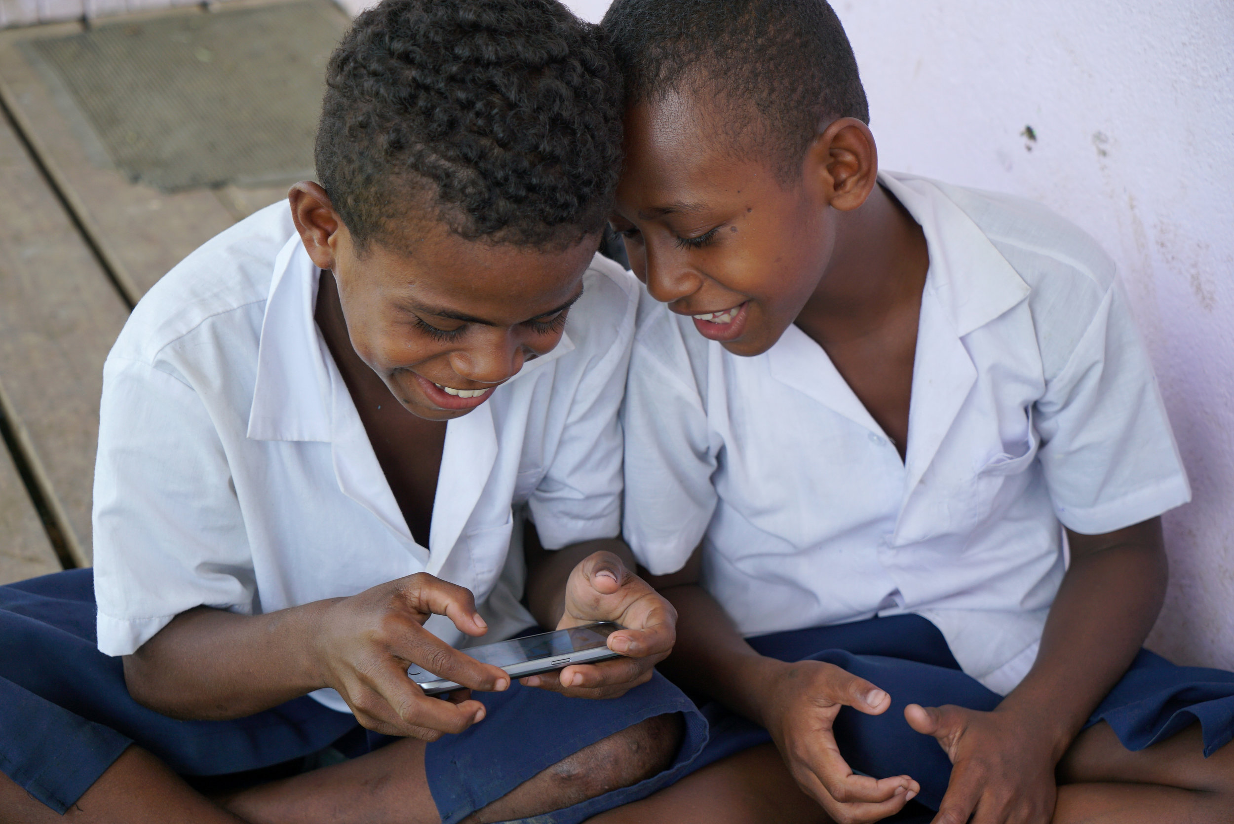 Students from Waiqanake Primary School in Fiji playing the BTS mobile game