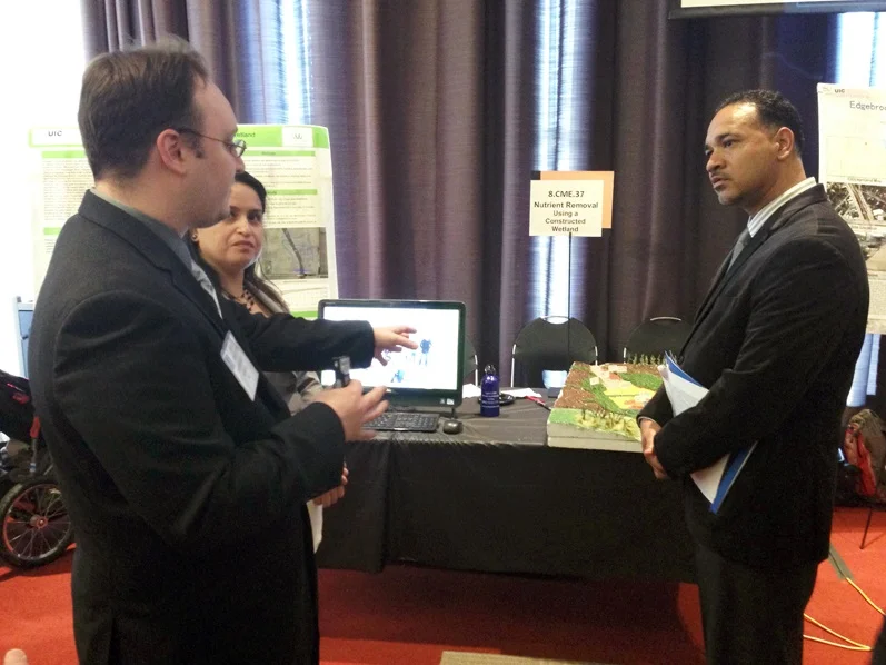 UIC senior engineering students Paul Jacobs (left), Diana Mejorado, and Caleb Carr (not pictured) present their farm-based wetland design at UIC’s annual engineering expo on April 22. Photo by Vera Leopold/TWI.
