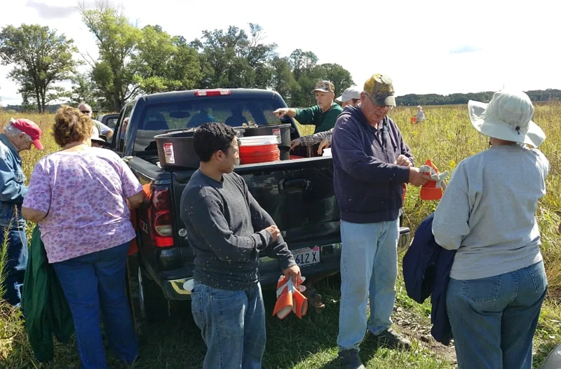 Volunteers return to the vehicles to deposit their harvest in bins and pick the “mementos” from the morning’s work off their clothes!