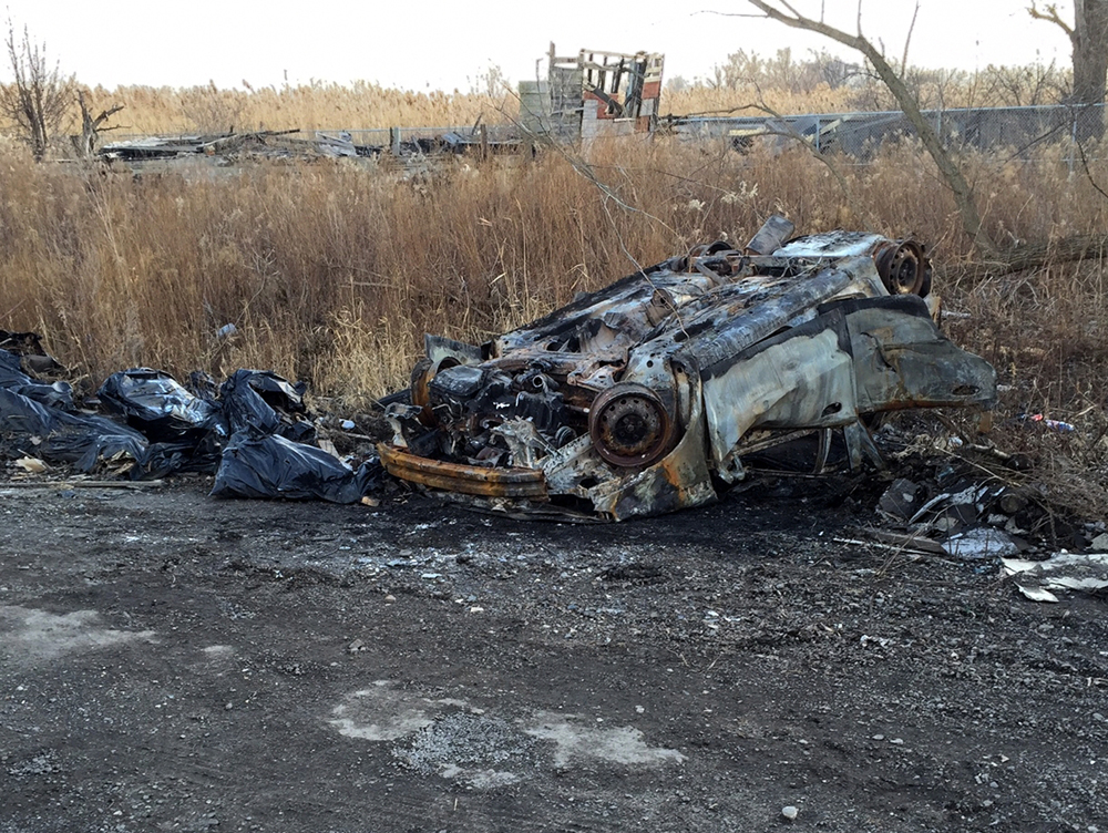 The burnt-out hulk of a car, an old foundation, and other debris will need to be removed to restore Indian Ridge Marsh. 