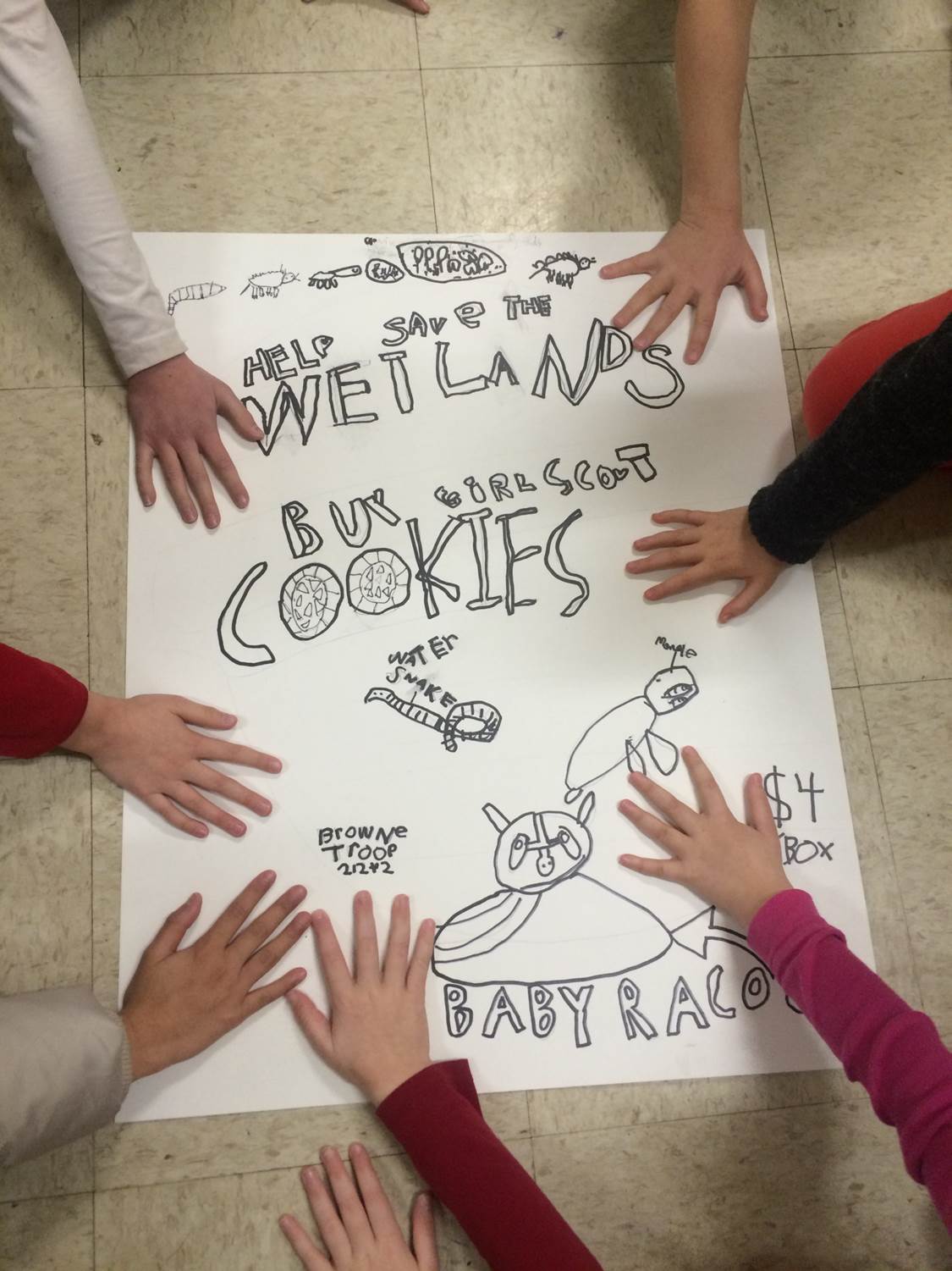 The Rainbow Troop displays one of the many posters they created for their cookie sale booths.