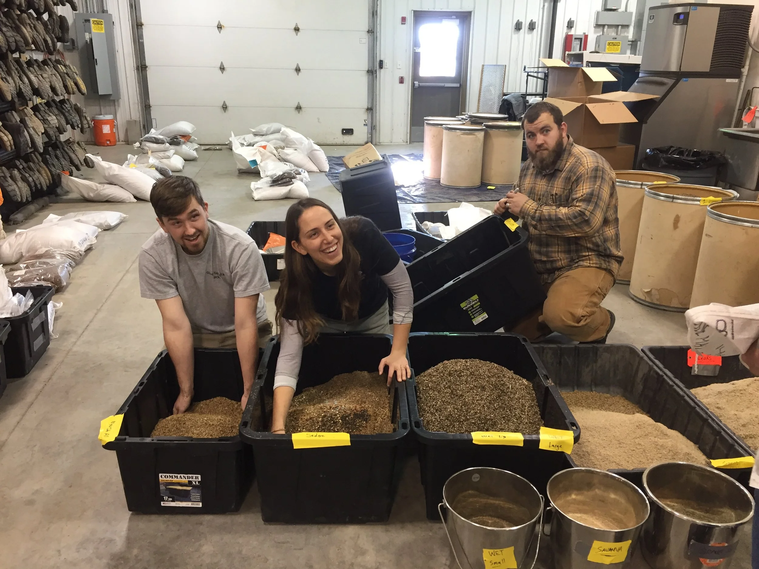 TWI field restoration crew members mix seed by hand in Midewin’s horticulture building. Photo by Phoebe Thatcher/TWI.