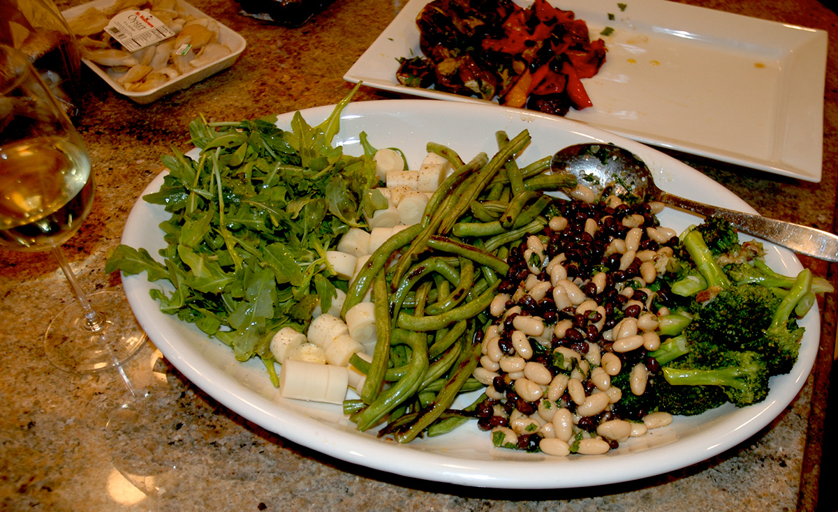 Greens and Whites platter is made up of arugula simply dressed with lemon juice, salt and olive oil, next to hearts of palm, sautéd string beans, 2 bean salad and roasted broccoli.