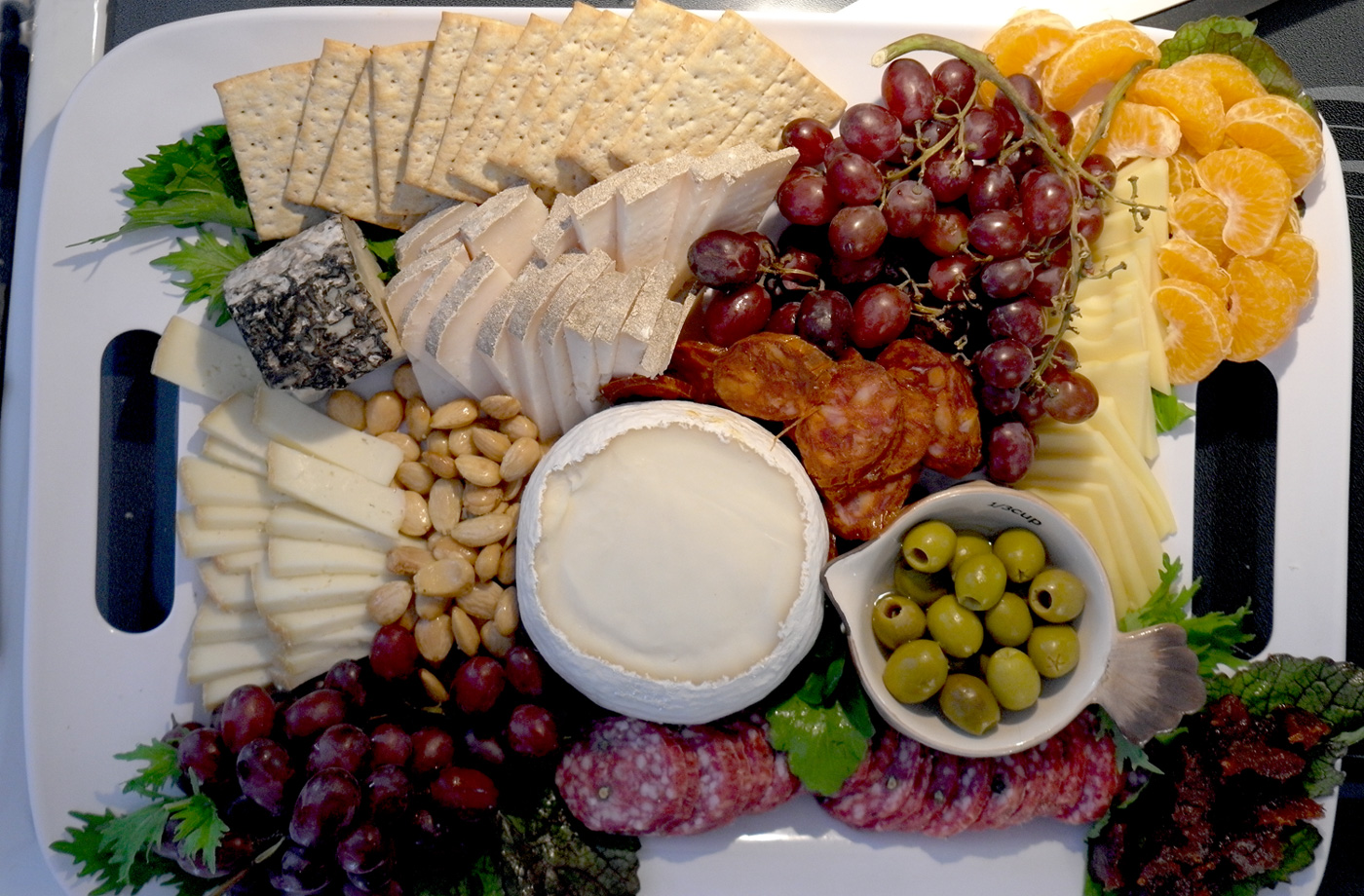 Using fruit of the season is a wonderful complement to cheese. If your cheese, meat and fruit choices feel like they are all in the same color scheme, tuck some herbs or greens on the edges for some visual anchoring.