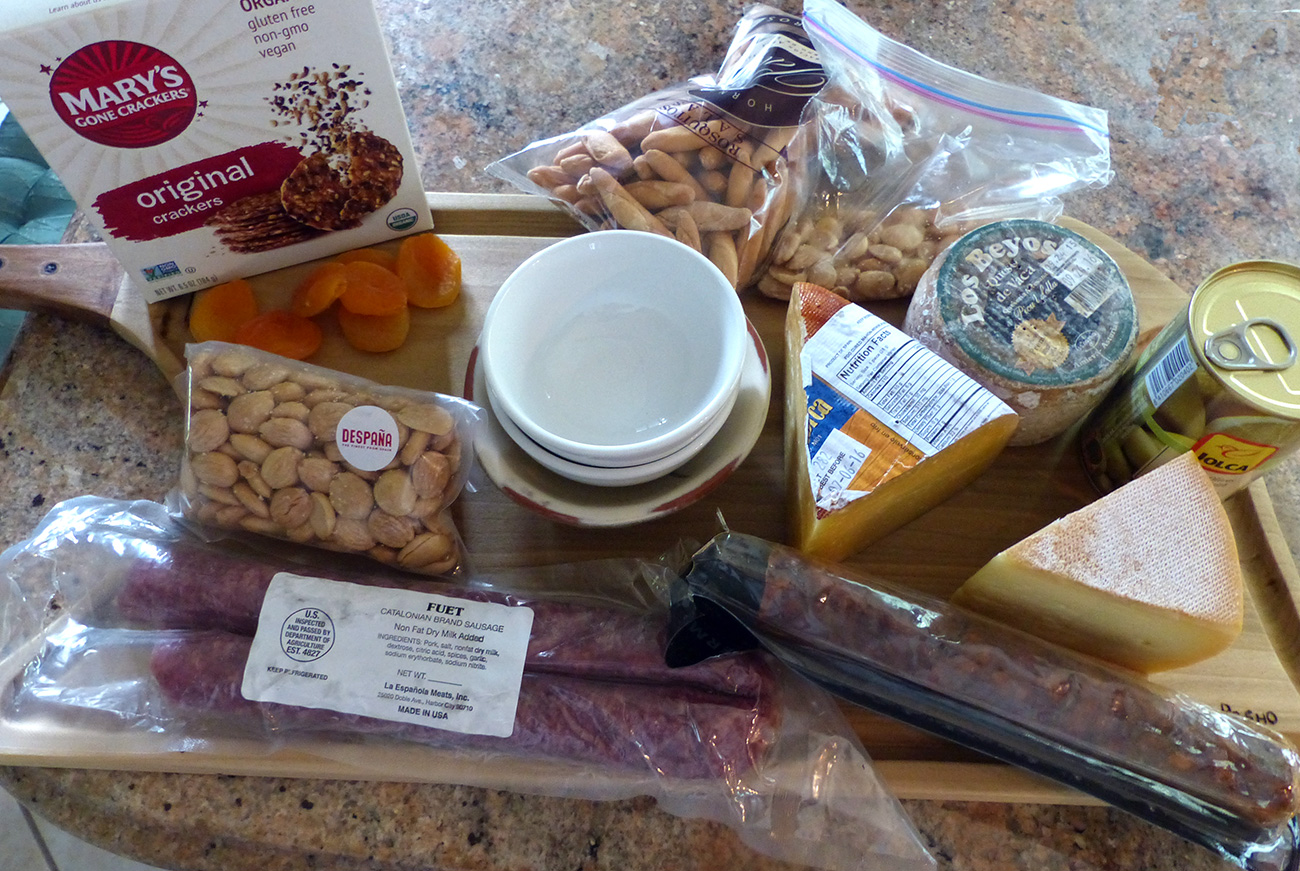Here is 2 types of dry cured sausage, 3 types of cheese, Marcona almonds, olives, dried apricots, gluten free crackers and short bread sticks.