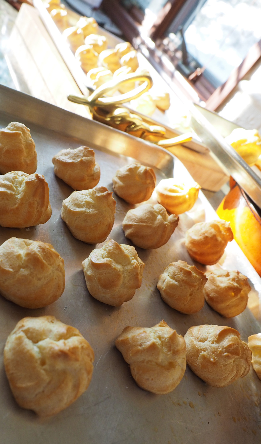 Lines of perfectly baked puffs awaiting their filling.