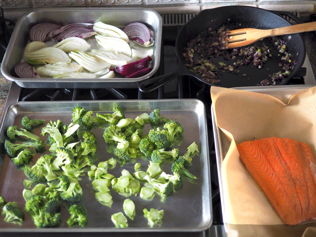 Prep everything in their pans, season right before putting in the oven and have a glass of wine.