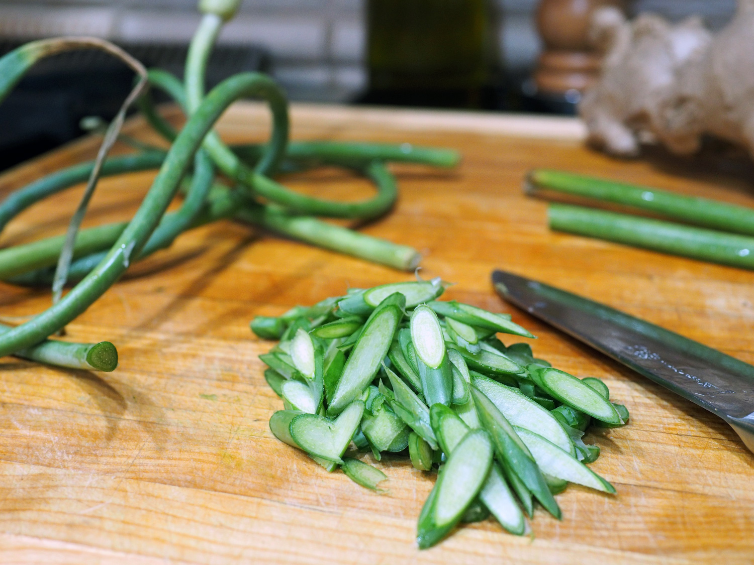 Thinly slice the garlic scapes. I like the diagonal, as it gives more surface area when sautéing. Also, cut off the end of the garlic scape and toss out, as this part, much like that of an asparagus, can be tough.