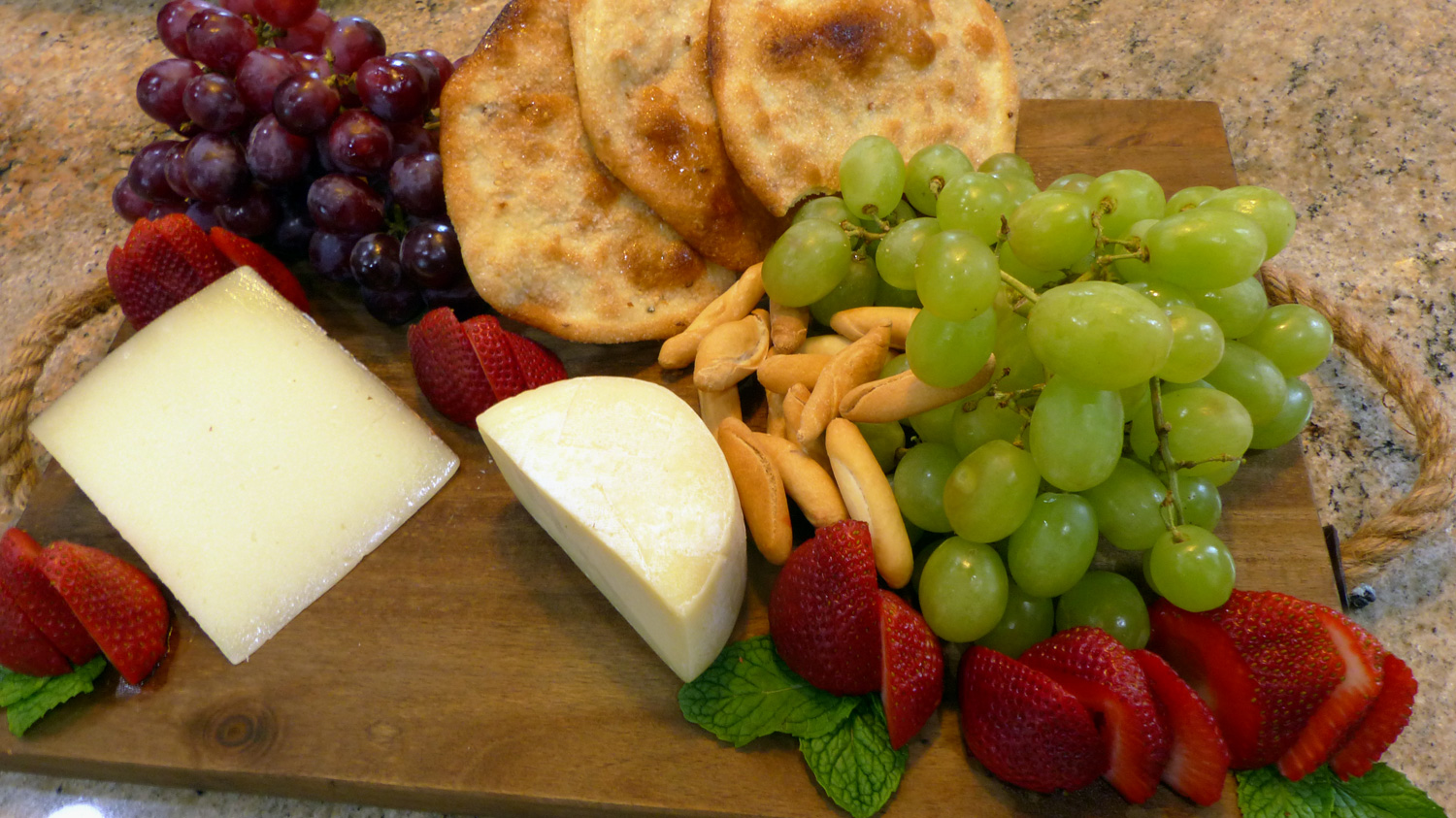 Cheeses with strawberries, grapes, mini bread sticks and Tortas de Aceite (Sweet Olive Oil Crackers).