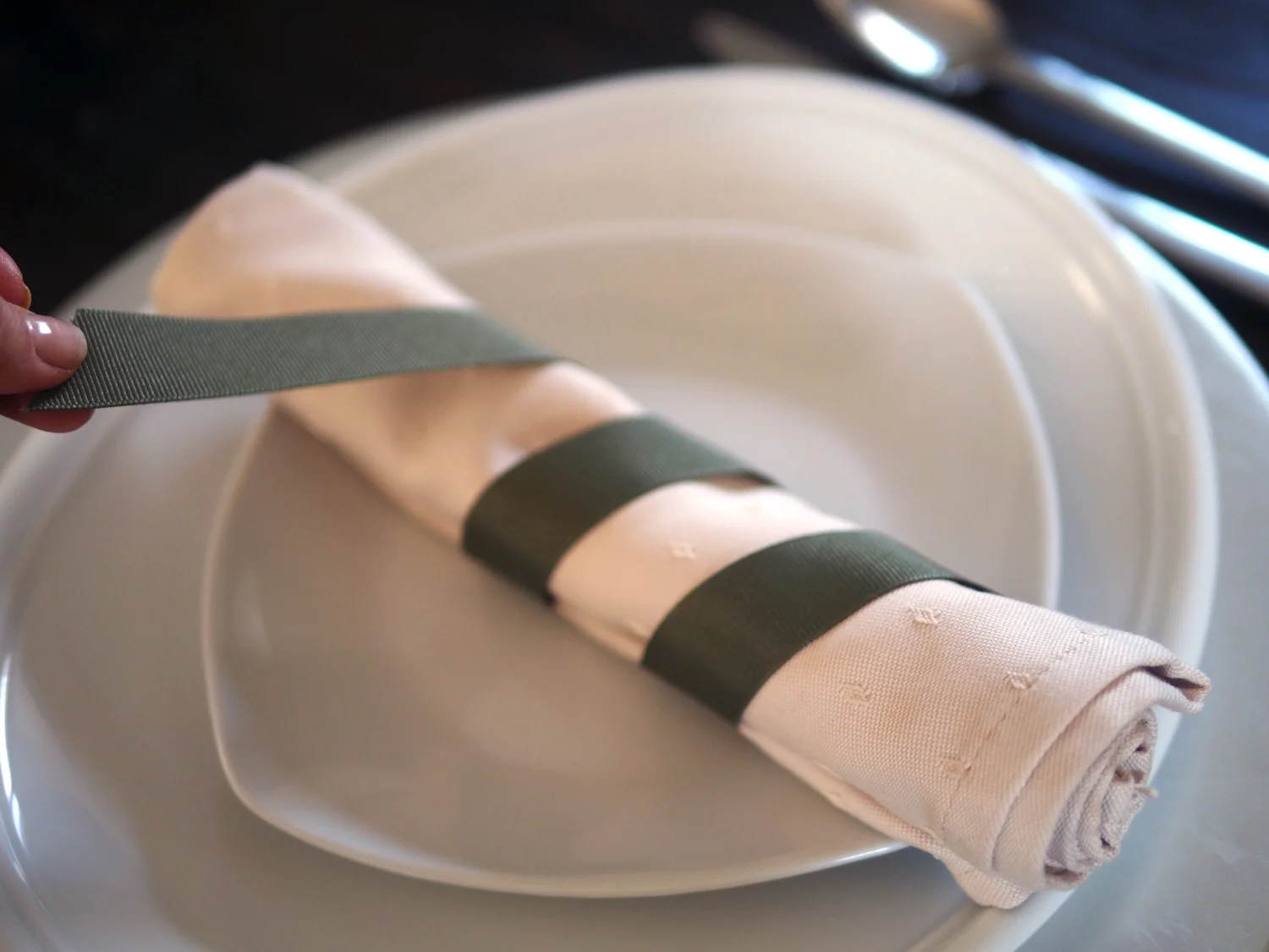 Using 1/2 grosgrain ribbon, tuck on end under the napkin and wind it around leaving equal amounts in between. Tuck the edge under.
