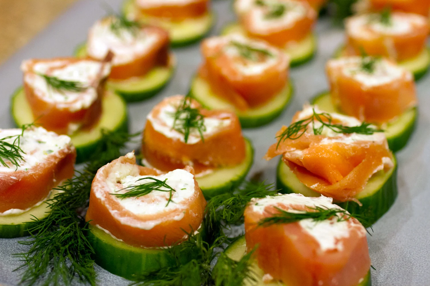 Salmon / cream cheese roll up a top a cucumber slice.