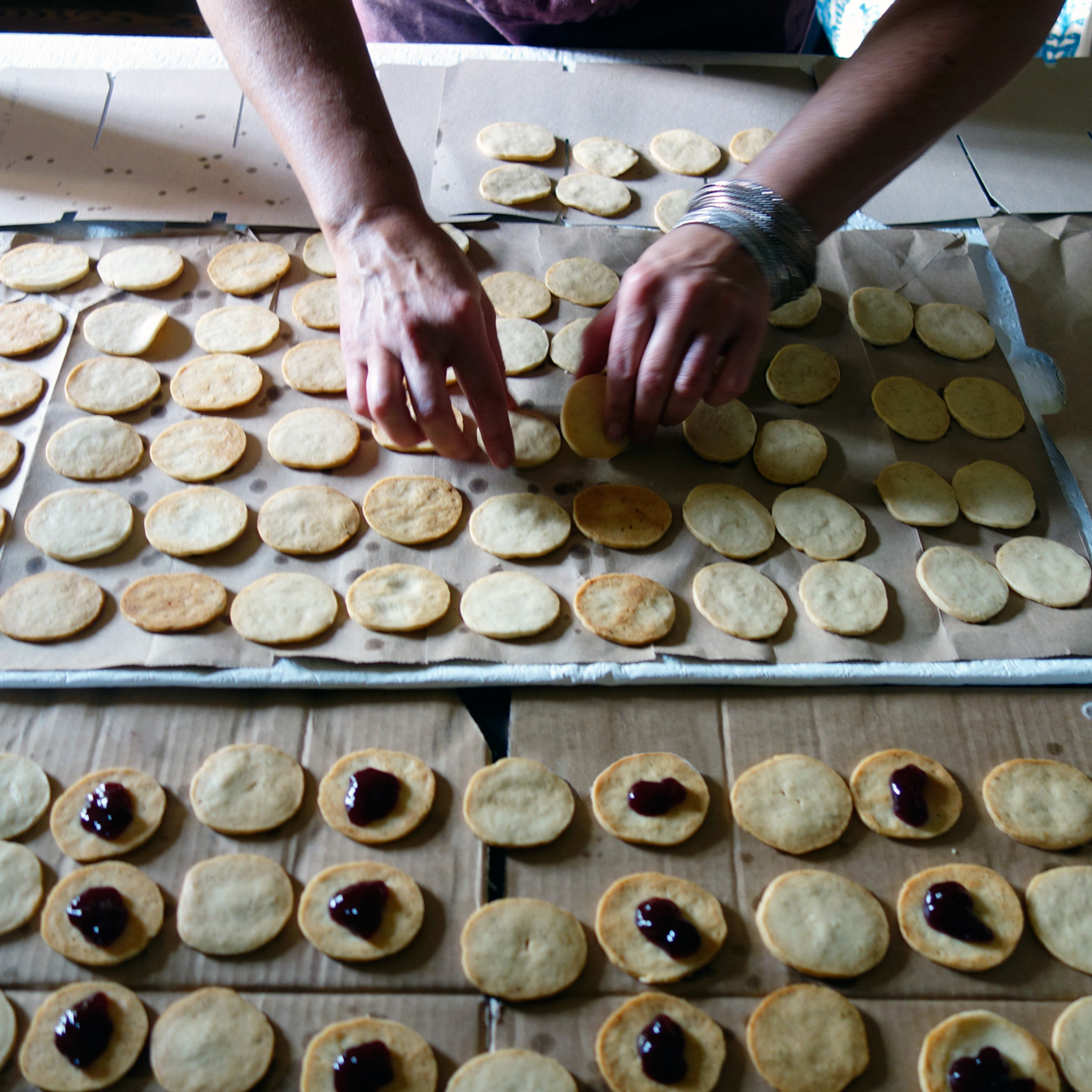 After they are lined up, turn one row over so you are filling the baked side with jam. Then the outside of the cookie looks nice when sandwiched together. Photo credit: asithappens.format.com
