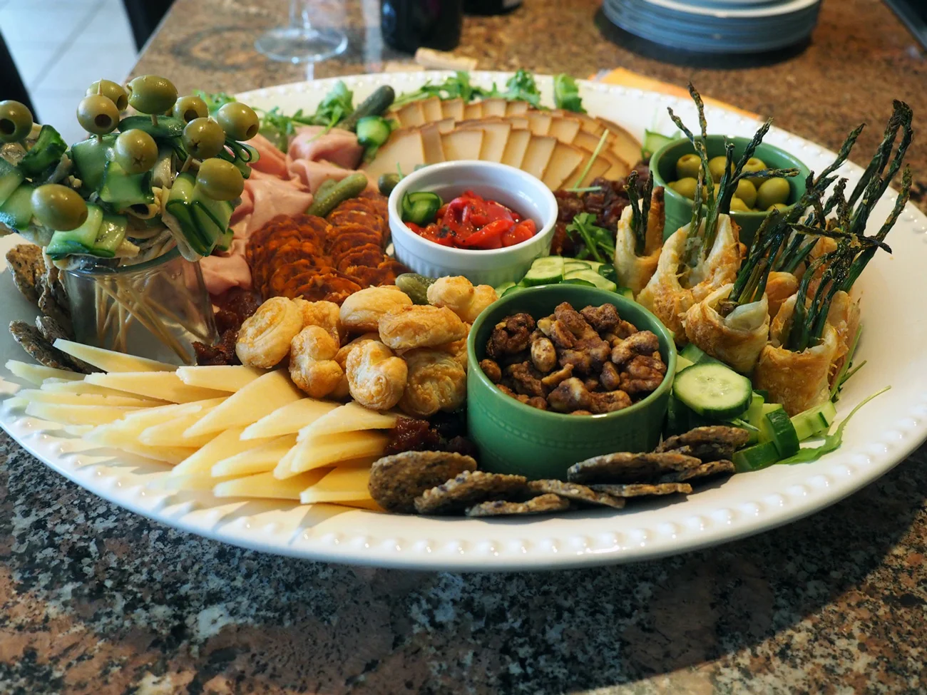 Those are boquerones skewers standing up in a glass jar. They look like lollipops. Rounding out the platter: Manchego and Majorero Pimentón cheeses, my spiced nuts , mortadella, Chorizo Vela , olives, roasted red pepppers, cucumbers and cornichon and Mary’s Gone Crackers .