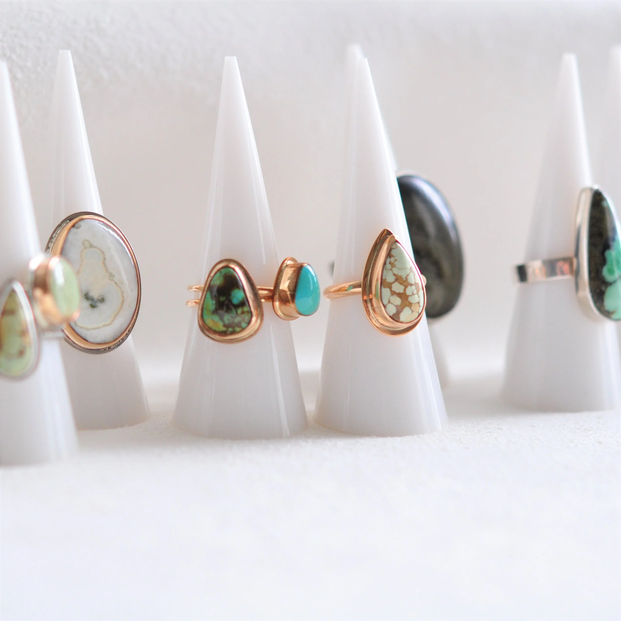 Several chunky gemstone rings in a variety of gems