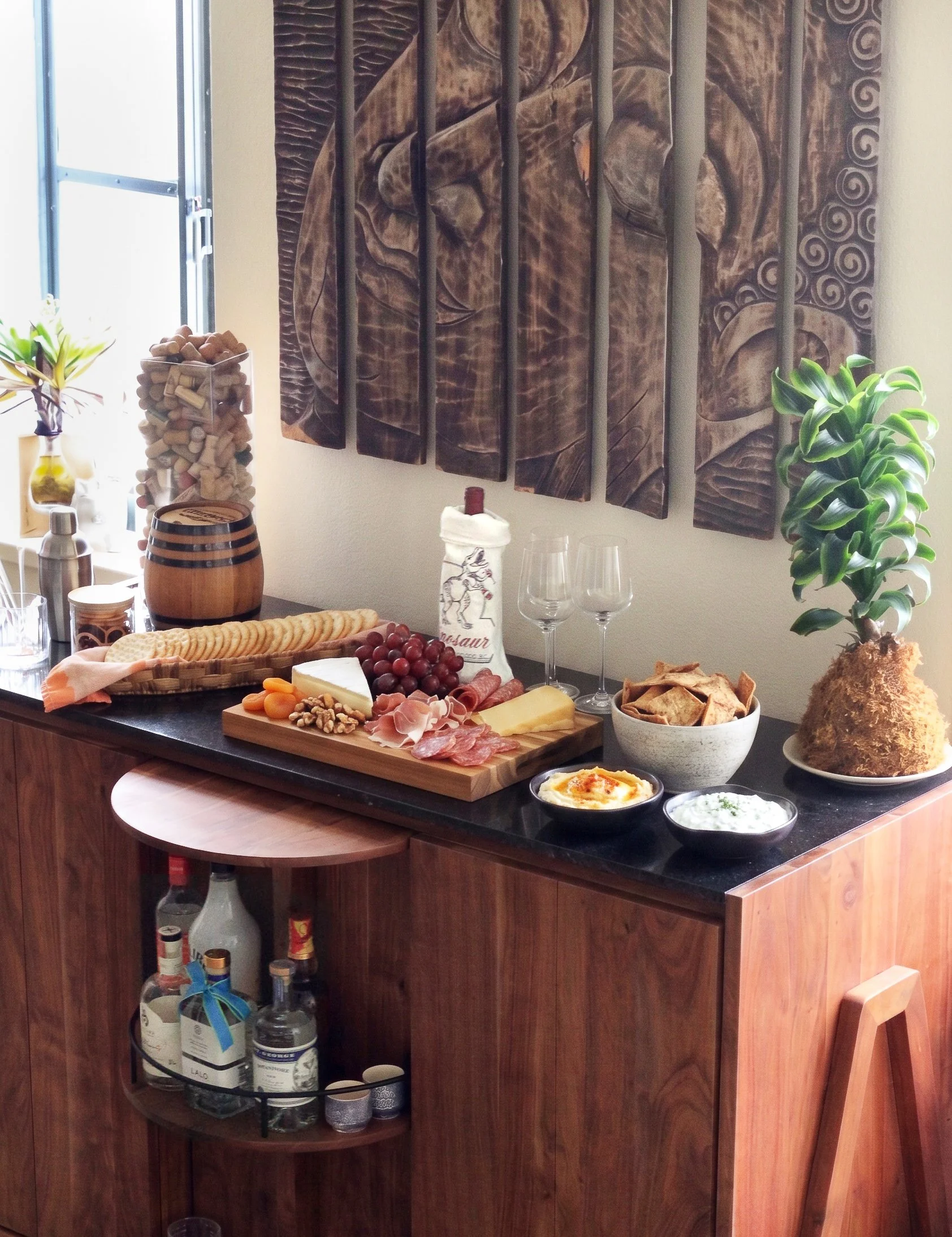a party spread on a bar with charcuterie wine and cocktails all served in handmade pieces
