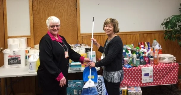 Mary Mosbey, coordinator for the basic needs drive and silent auction, and Executive Director, Linda Wiza, showcasing the basic needs collected. 