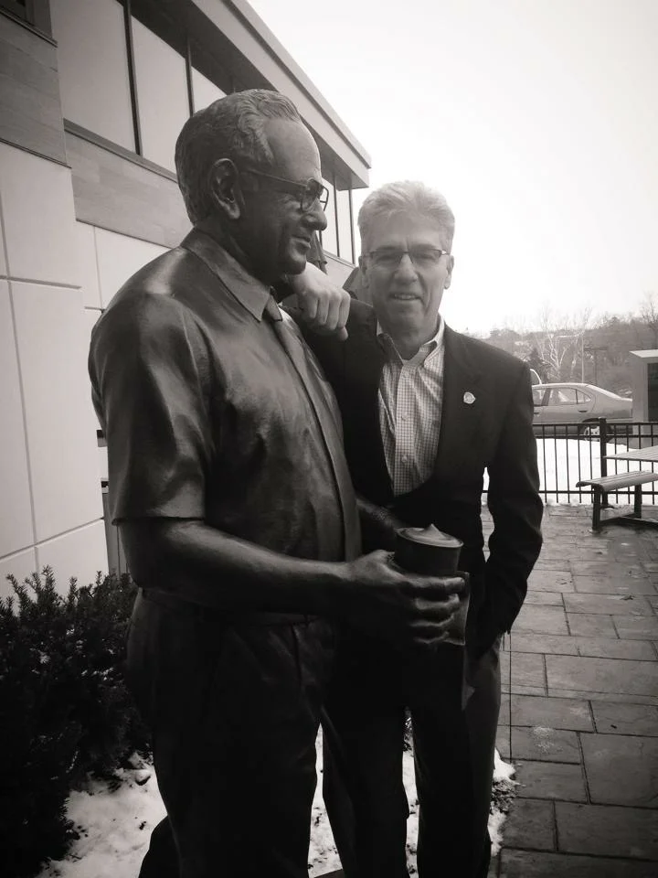 Denny poses by a statue of Dave at the opening of Wendy's Flagship restaurant in December 2013.