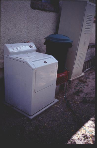 Figure 2: Collection of graywater from an outdoor, low-water-using washing machine into a barrel that feeds a vegetable garden through a hose.