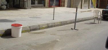 Makeshift parking obstacles placed along the side of a street. (Basma Abdallah)