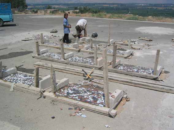   View of the concrete benches under construction showing the ceramic tile designs as created by the students.  