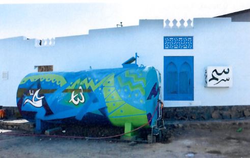  Images of the water tanks that participating artists covered in brightly-colored, abstract designs 