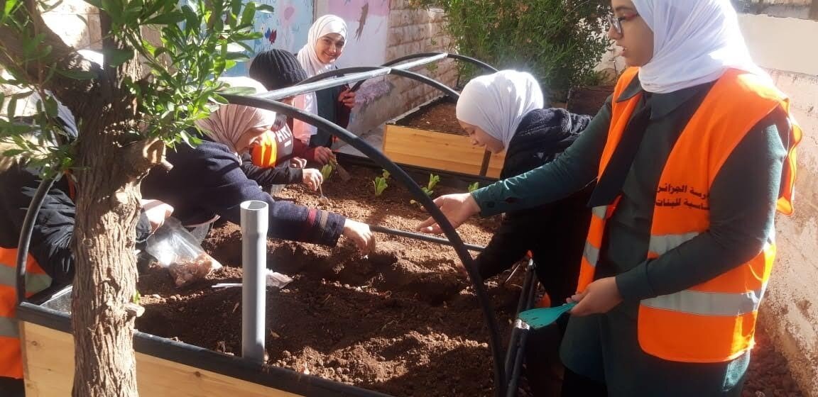  Students carrying out planting activities relating to one of the planting beds installed in the school. The pipe that appears in the foreground of the photo is where the water supply for the planting bed’s capillary irrigation system is poured. 