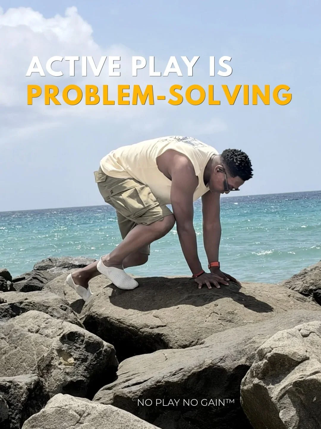 Darryl Edwards moves on hands and feet across seaside rocks, finding a route over the uneven surface.