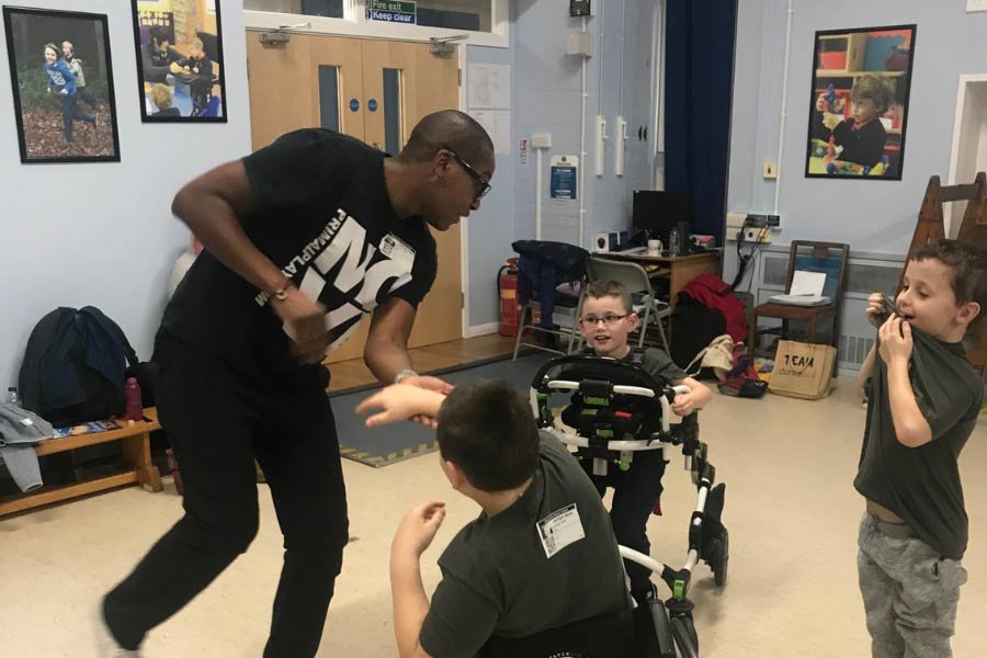 Darryl Edwards playing tag with children.