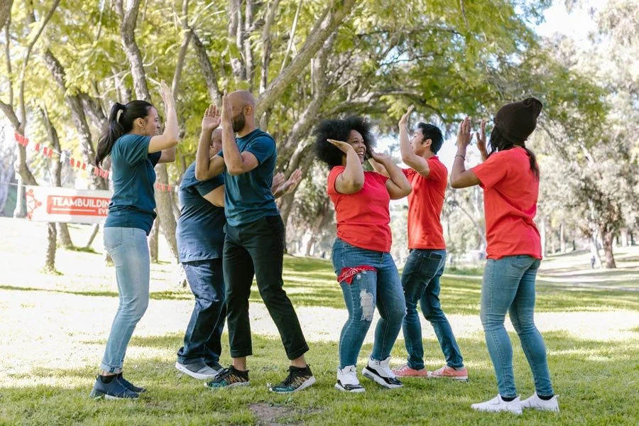 Group of adults taking part in a playful movement challenge.