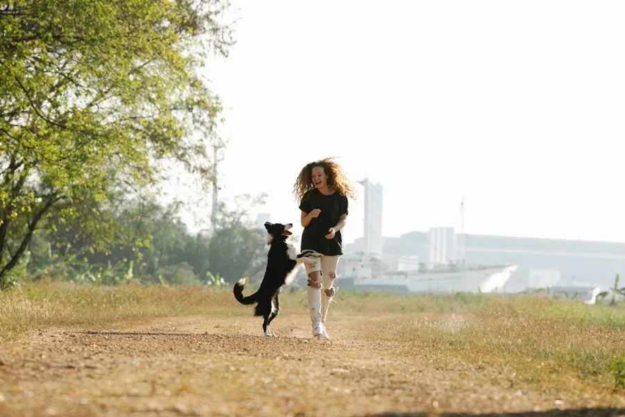 Woman running outdoors with her dog.