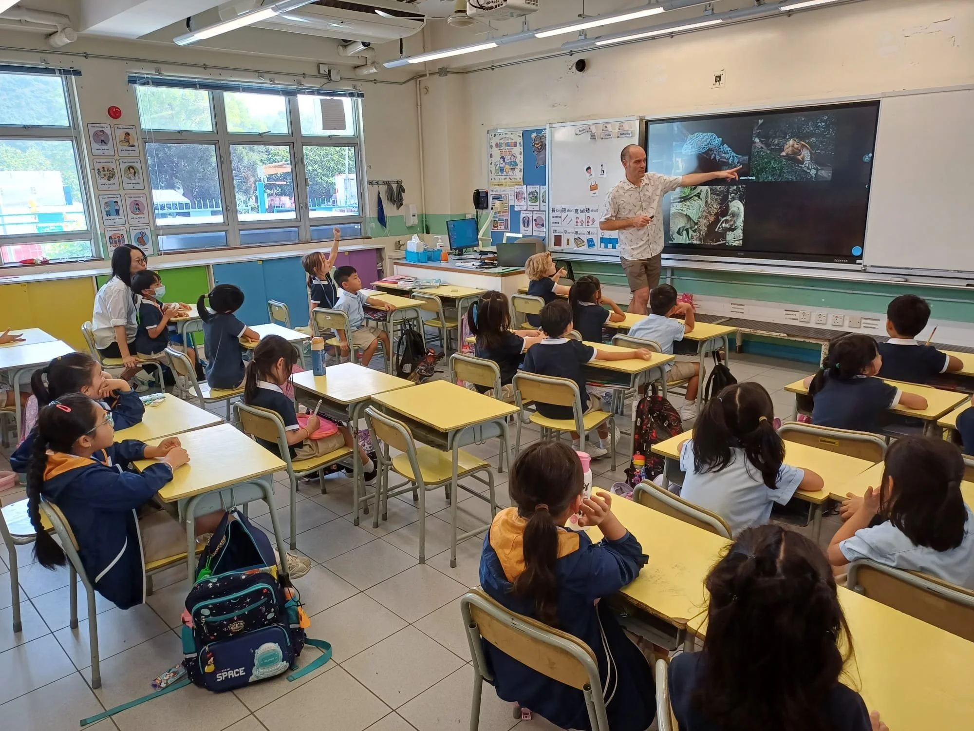 William educates children about snakes at a school in Hong Kong.