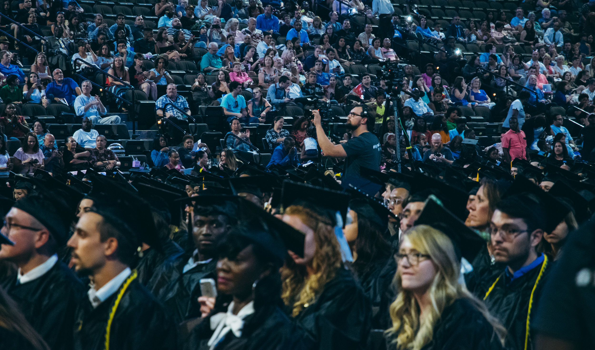 On the main camera, Curtis films graduates receiving their diplomas.