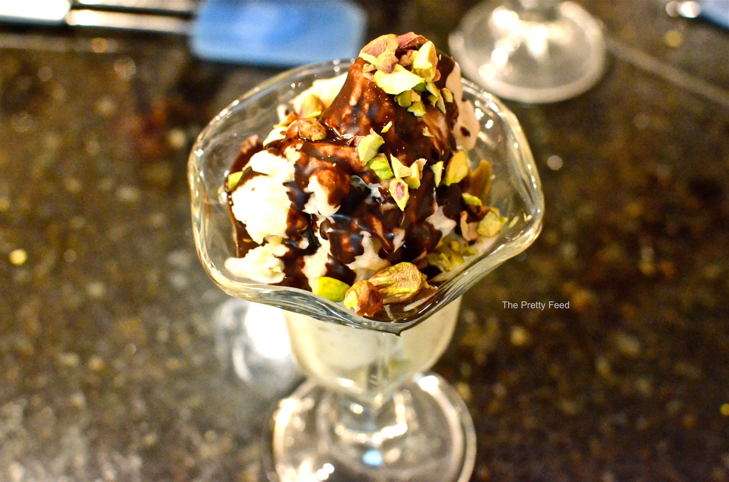 Finally, poor the hot chocolate sauce onto each sunday and watch it magically harden. Next sprinkle the chopped pistachios over it and enjoy!!! 