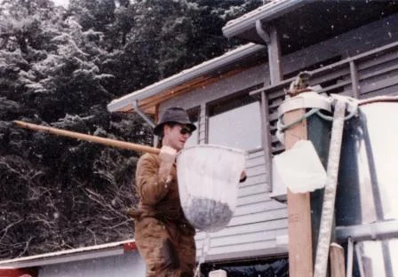 In the beginning years of DIPAC, Ladd hoists salmon fry from a raceway at Kowee Creek hatchery.